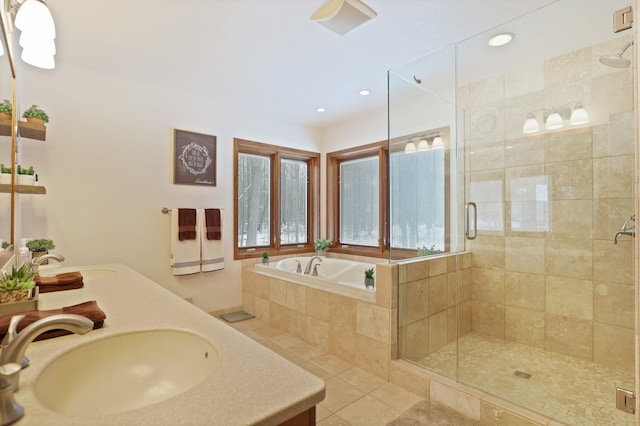 full bath featuring a garden tub, a shower stall, a sink, and tile patterned floors