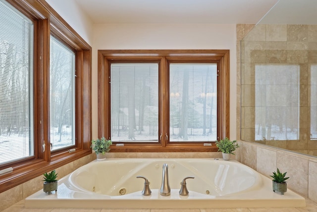 bathroom featuring a wealth of natural light and a tub with jets