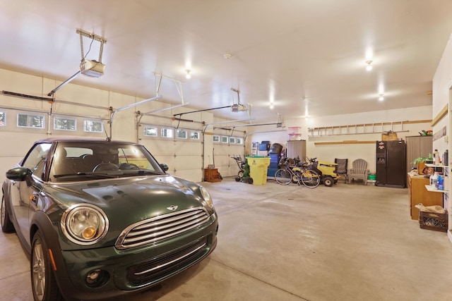 garage with black fridge with ice dispenser and a garage door opener