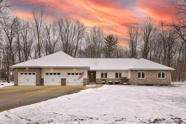 single story home featuring a garage and aphalt driveway