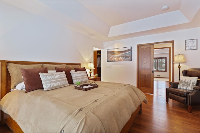 bedroom featuring a tray ceiling and wood finished floors