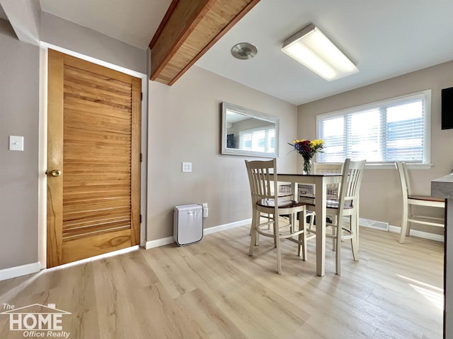 dining area featuring visible vents, light wood-style flooring, and baseboards