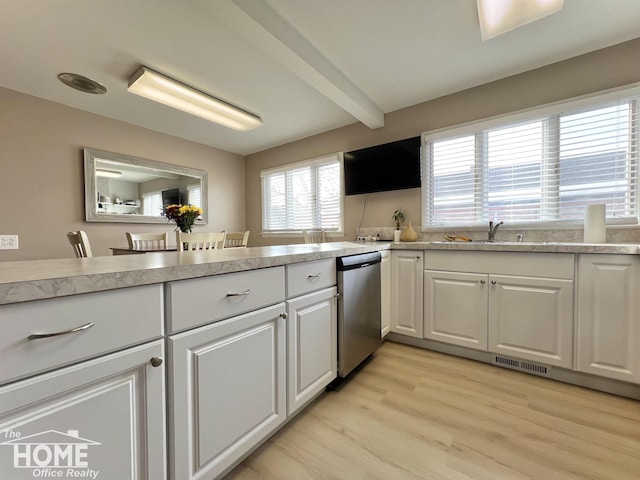 kitchen with dishwasher, beamed ceiling, light countertops, light wood-type flooring, and white cabinetry