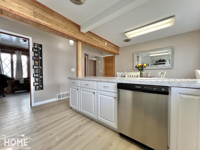 kitchen featuring visible vents, white cabinets, light countertops, stainless steel dishwasher, and beam ceiling