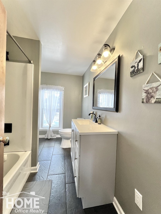 full bath with  shower combination, baseboards, vanity, and toilet