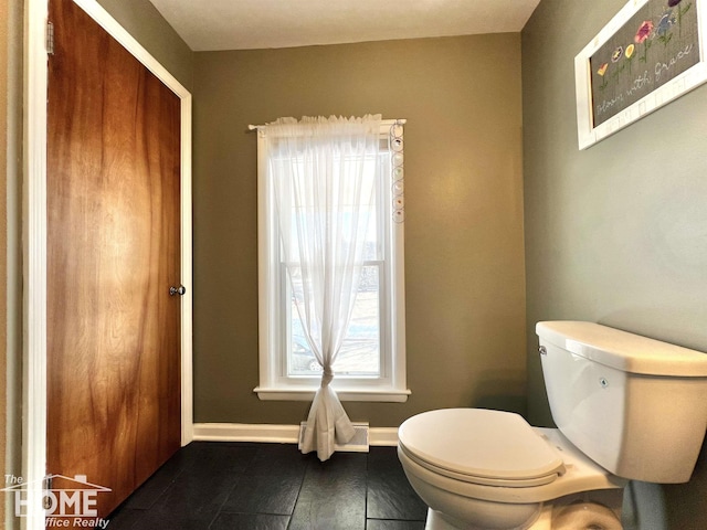 half bathroom with toilet and baseboards