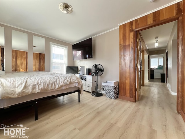 bedroom featuring baseboards, light wood-type flooring, and crown molding