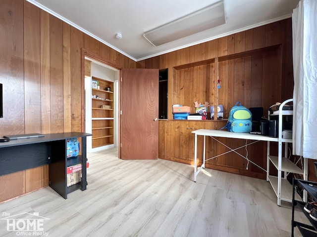 office area featuring light wood-style floors, wood walls, and crown molding