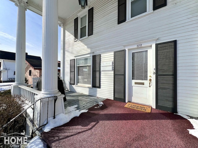 view of exterior entry featuring covered porch