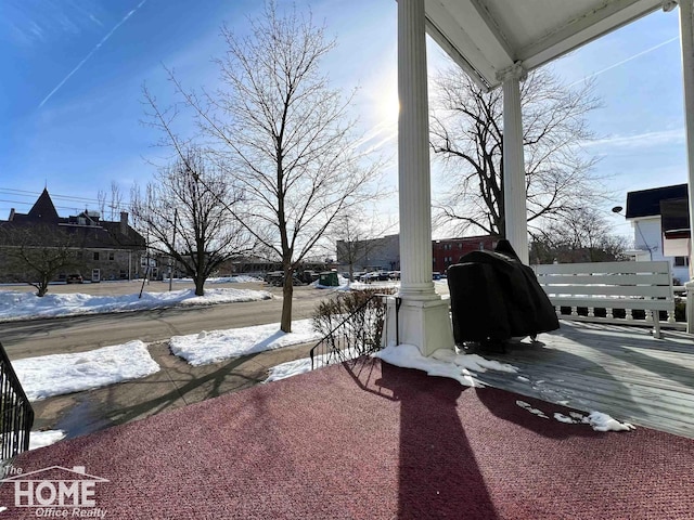 snow covered patio with a grill