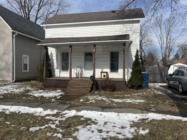 view of front facade with covered porch and a shingled roof