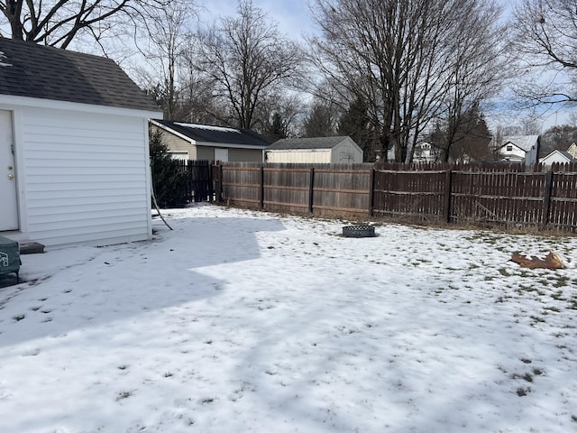 snowy yard featuring a fenced backyard