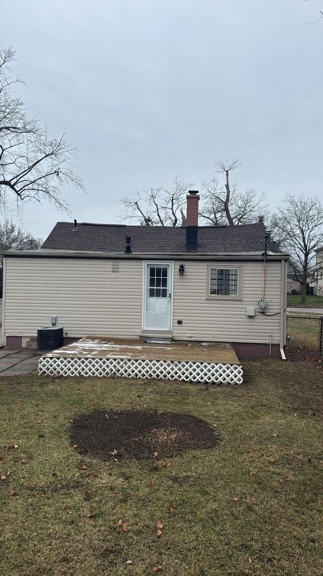 rear view of property with entry steps, a chimney, and a yard