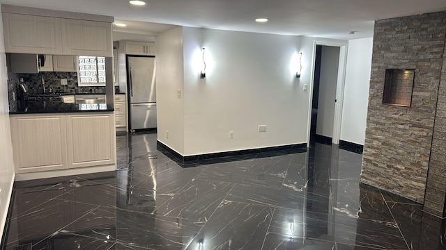 interior space with marble finish floor, baseboards, and recessed lighting