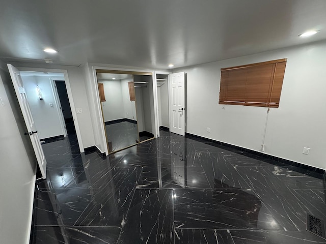 spare room featuring marble finish floor, recessed lighting, and baseboards