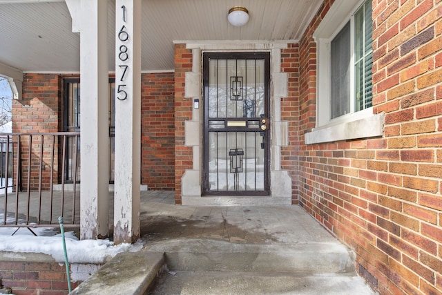 view of exterior entry with brick siding