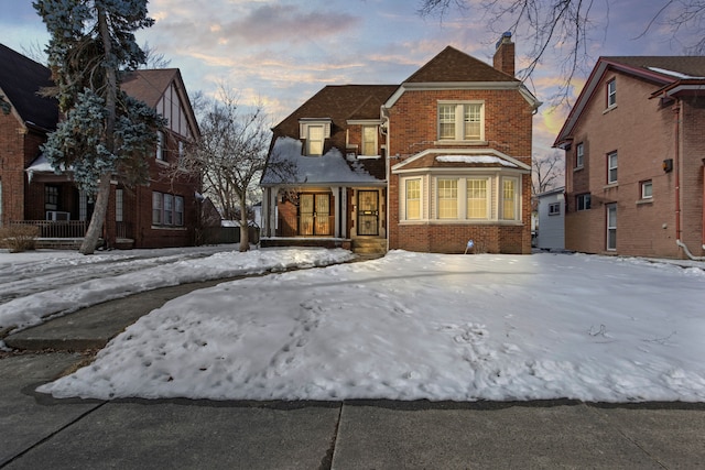 view of front of property featuring a chimney and brick siding