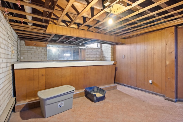 finished below grade area featuring wood walls and brick wall