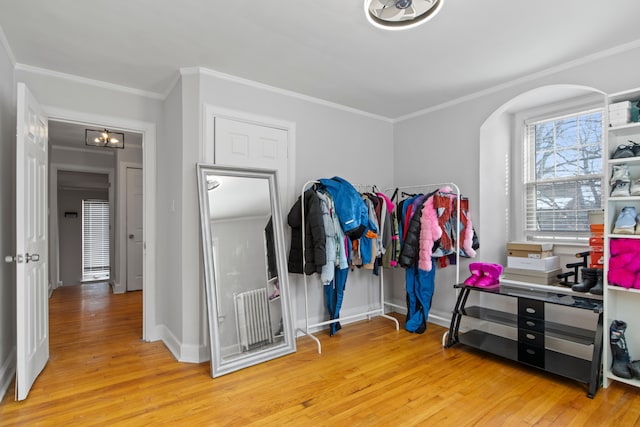 walk in closet featuring light wood-type flooring and arched walkways