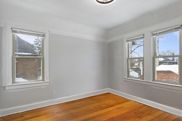 empty room with baseboards and wood finished floors