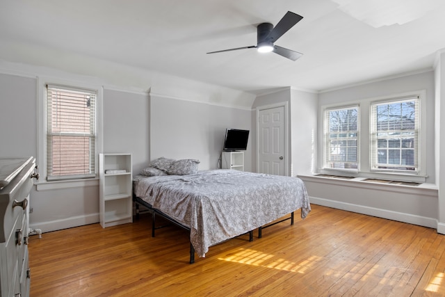 bedroom with baseboards, ornamental molding, and light wood-style floors