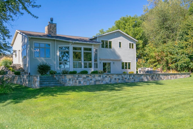 rear view of house featuring a yard and a chimney