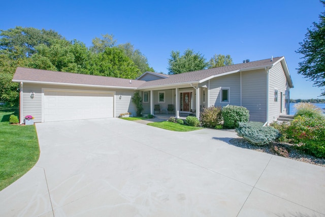 single story home with an attached garage, a porch, and concrete driveway