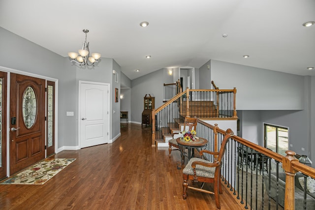 foyer featuring baseboards, lofted ceiling, stairway, dark wood-type flooring, and a notable chandelier