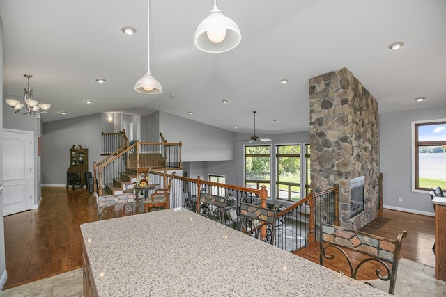 kitchen with plenty of natural light, a stone fireplace, and light stone countertops