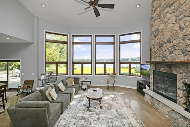 living room with ceiling fan, recessed lighting, a fireplace, and baseboards