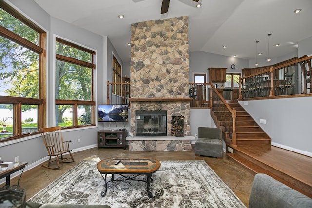 tiled living room featuring baseboards, lofted ceiling, ceiling fan, stairway, and a stone fireplace