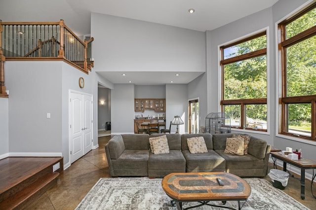 living room featuring a high ceiling, a wealth of natural light, and recessed lighting