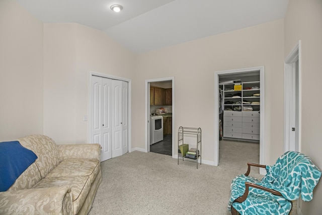 sitting room with vaulted ceiling, carpet, washer / dryer, and baseboards