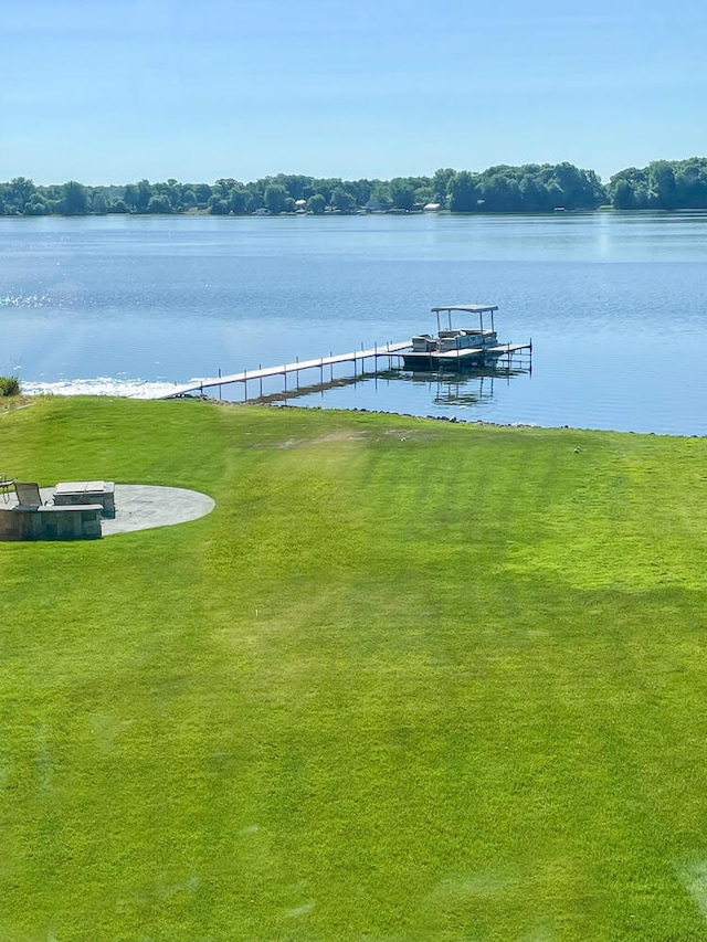 view of dock featuring a lawn and a water view