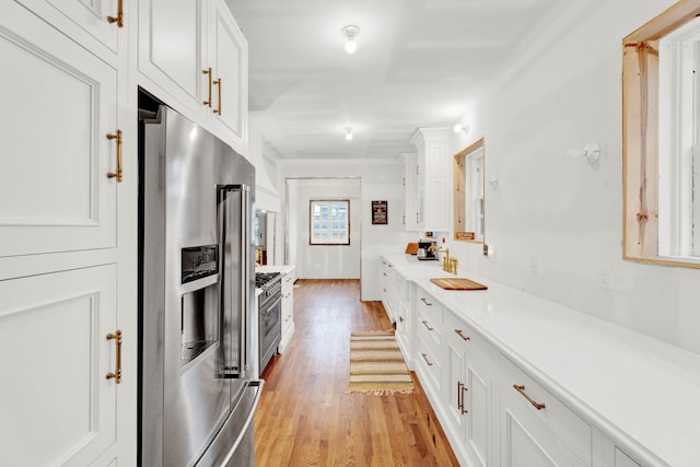 kitchen featuring appliances with stainless steel finishes, white cabinets, and light wood-style floors