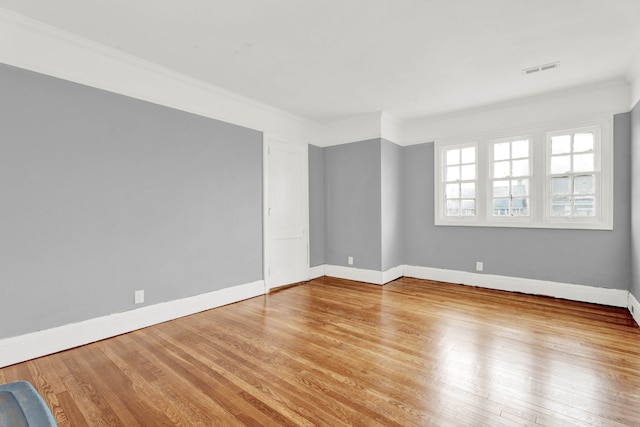 unfurnished room featuring visible vents, crown molding, light wood-style flooring, and baseboards