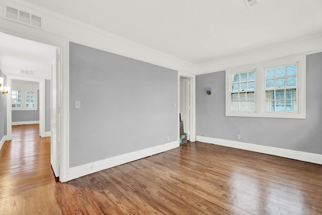 empty room with visible vents, baseboards, and wood finished floors