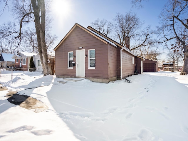 view of front of property featuring a garage, a chimney, and fence