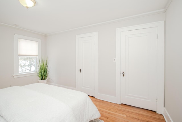 bedroom featuring crown molding, baseboards, and wood finished floors