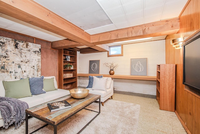 living room featuring beamed ceiling, built in features, and wooden walls