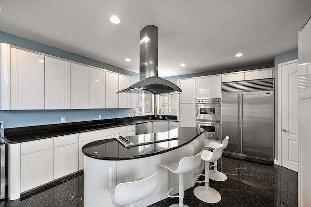 kitchen featuring granite finish floor, recessed lighting, stainless steel appliances, dark countertops, and island range hood