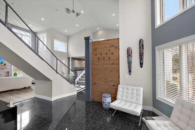 sitting room with baseboards, stairway, recessed lighting, a high ceiling, and granite finish floor