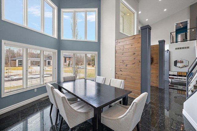 dining space featuring recessed lighting, baseboards, a towering ceiling, and granite finish floor