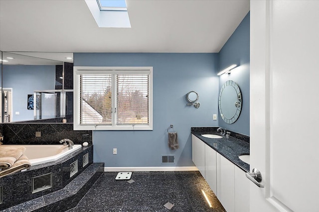 bathroom featuring visible vents, baseboards, a skylight, a sink, and a shower stall