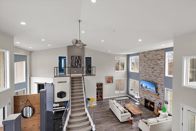 living room featuring high vaulted ceiling, wood finished floors, recessed lighting, stairway, and a fireplace