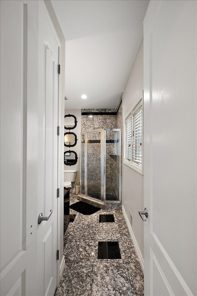 bathroom with recessed lighting, a shower stall, and baseboards