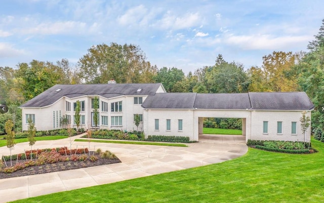 view of front of house with a front yard and curved driveway