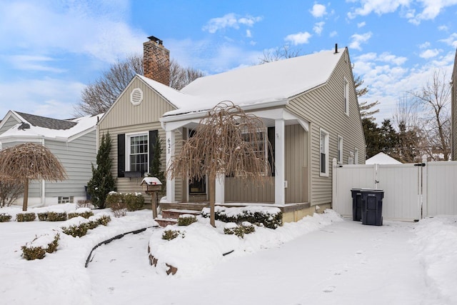 view of front of property featuring a gate, fence, and a chimney