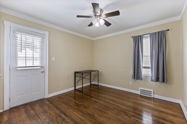 empty room featuring dark wood-style flooring, visible vents, and baseboards