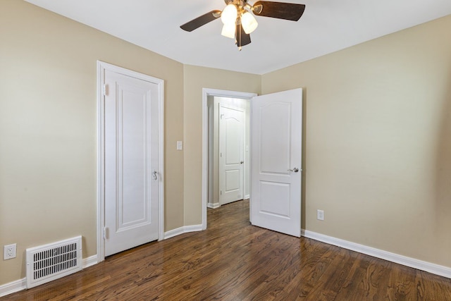 unfurnished bedroom with dark wood-style floors, ceiling fan, visible vents, and baseboards